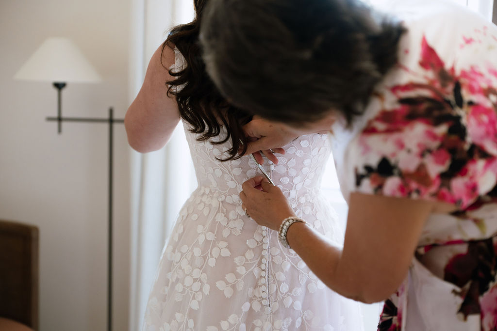 Bride getting hair and makeup done in a naturally lit suite at Kimpton Santo San Antonio