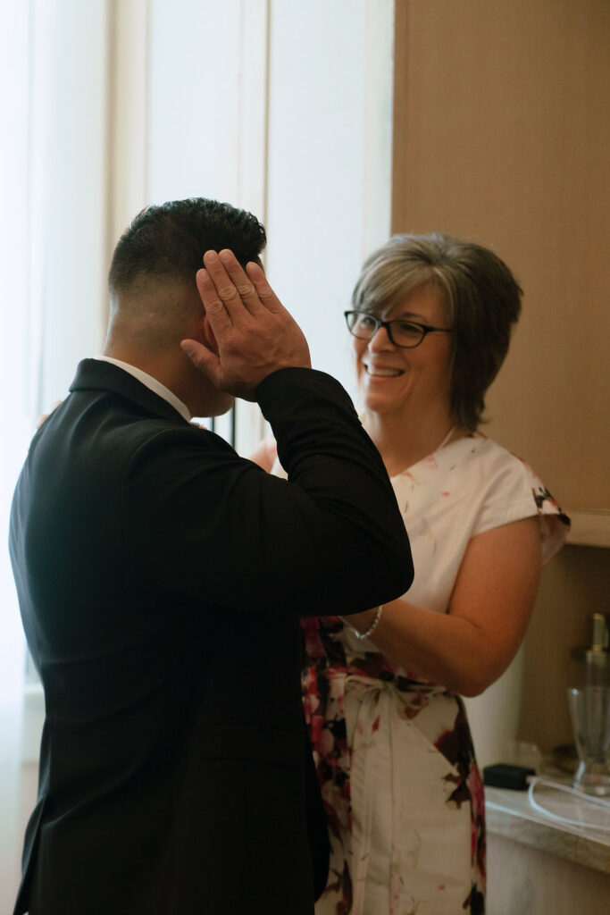 Groom blindfolded in a Kimpton Santo Hotel room for a private first look with the bride