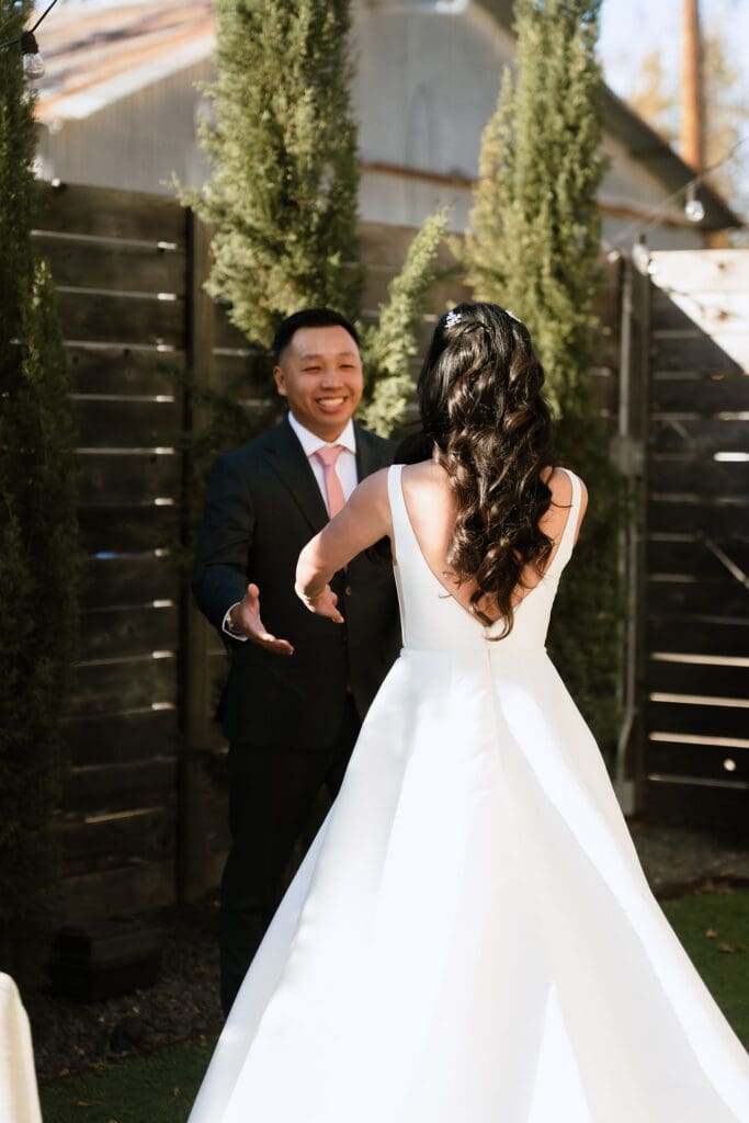 Groom sees his bride for the first time during their winter wedding first look at One Eleven East in Hutto Texas