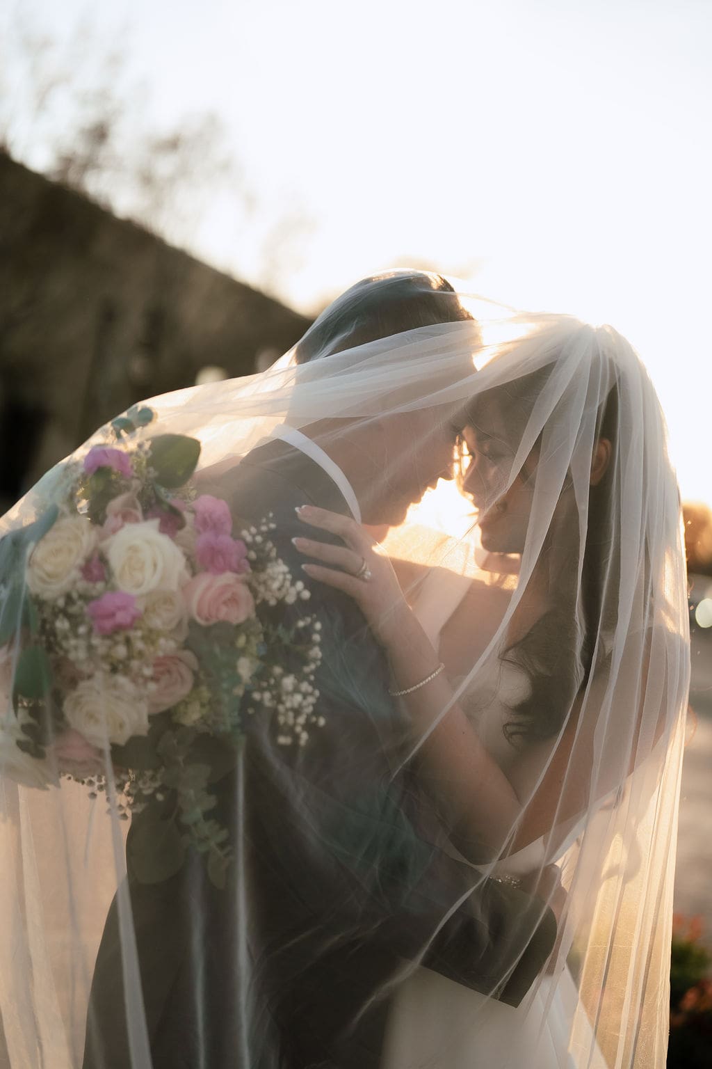 Newlyweds embracing during golden hour portraits at One Eleven East winter wedding in Hutto Texas, captured by Andrea Jang Photography