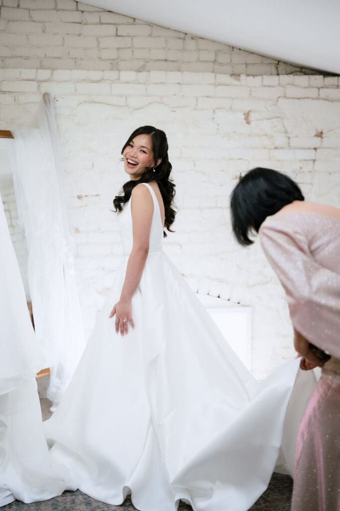 Bride smiling in her wedding dress at One Eleven East in Hutto Texas, beautiful winter wedding portrait by Andrea Jang Photography