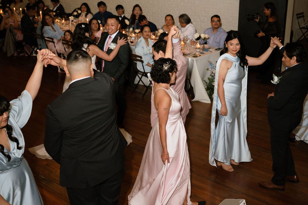 Guests celebrating at a romantic winter wedding reception at One Eleven East venue in Hutto Texas, photographed by Andrea Jang