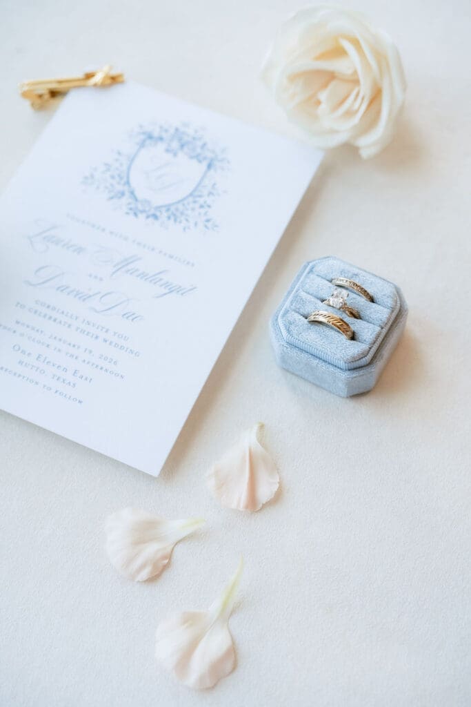 Close up of wedding rings and invitation at One Eleven East winter wedding in Hutto Texas, photographed by Andrea Jang Photography