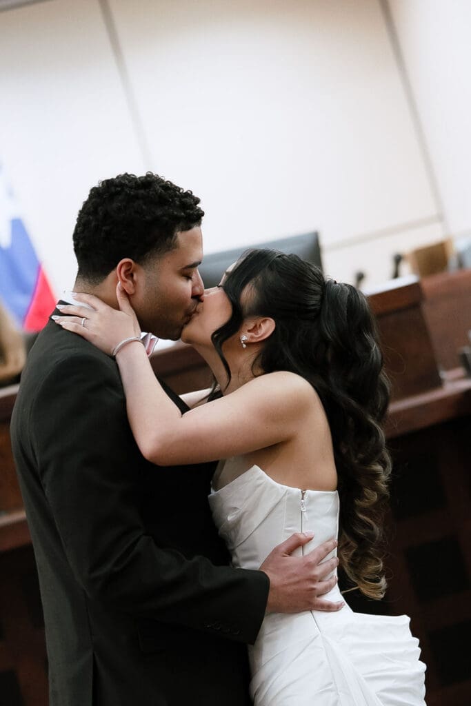 Newlyweds sharing first kiss portrait at Judge Helen Petry Stowe Courthouse 1 San Antonio Texas