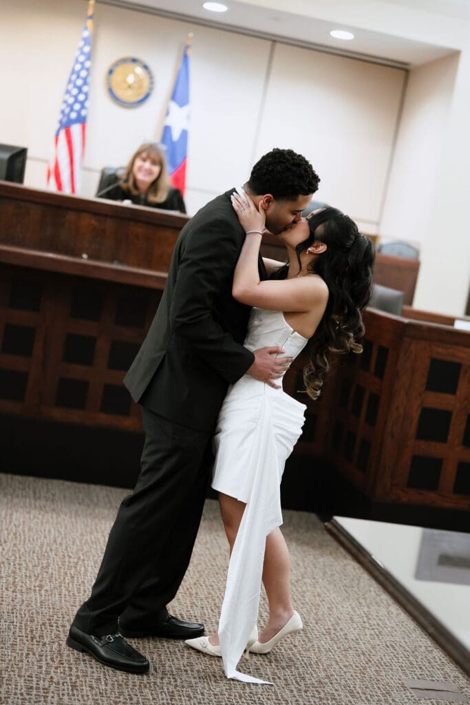 Newlyweds sharing first kiss portrait at Judge Helen Petry Stowe Courthouse 1 San Antonio Texas
