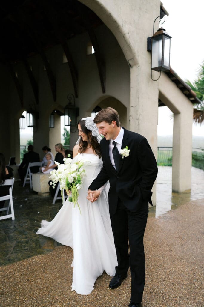 Couple laughing in the rain during wedding portraits at Chapel Dulcinea Texas Hill Country