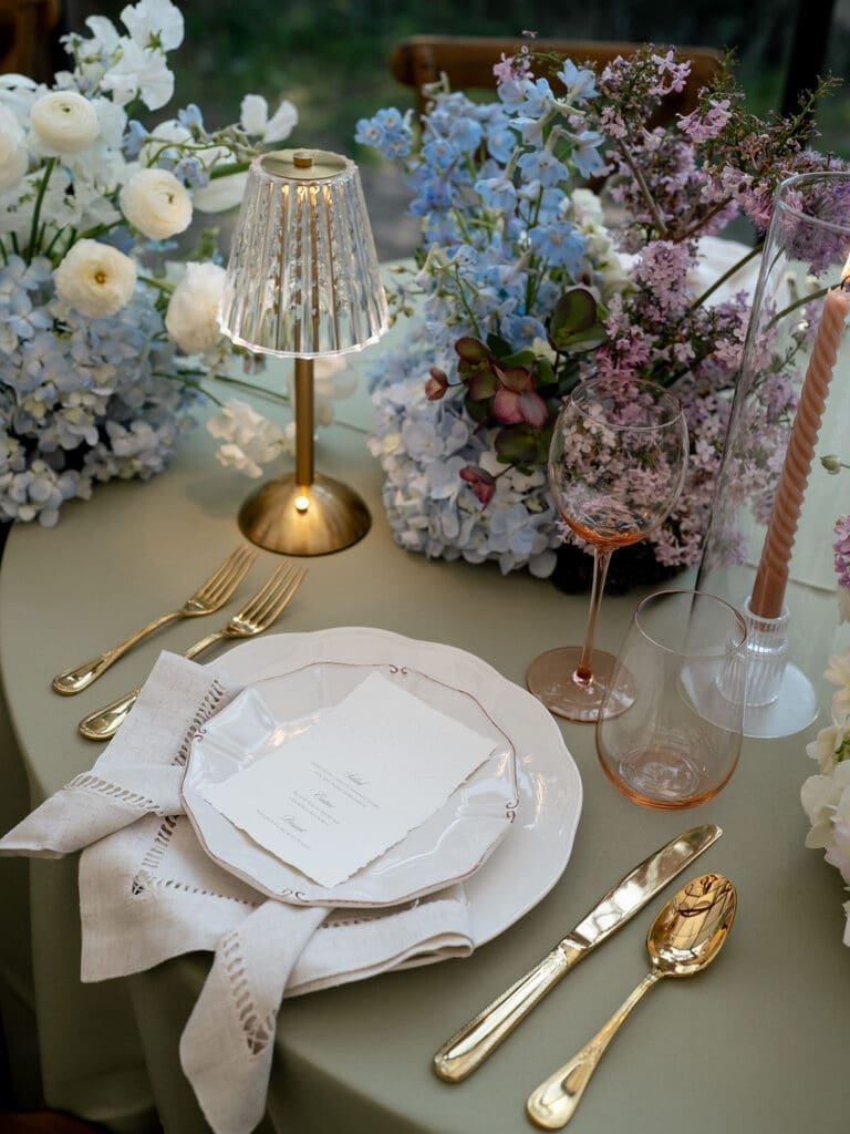Monet inspired wedding reception tablescape with sage green velvet linens, impressionist floral centerpieces, and peach taper candles at Wild Roots Lockhart Texas, photographed by Austin wedding photographer Andrea Jang