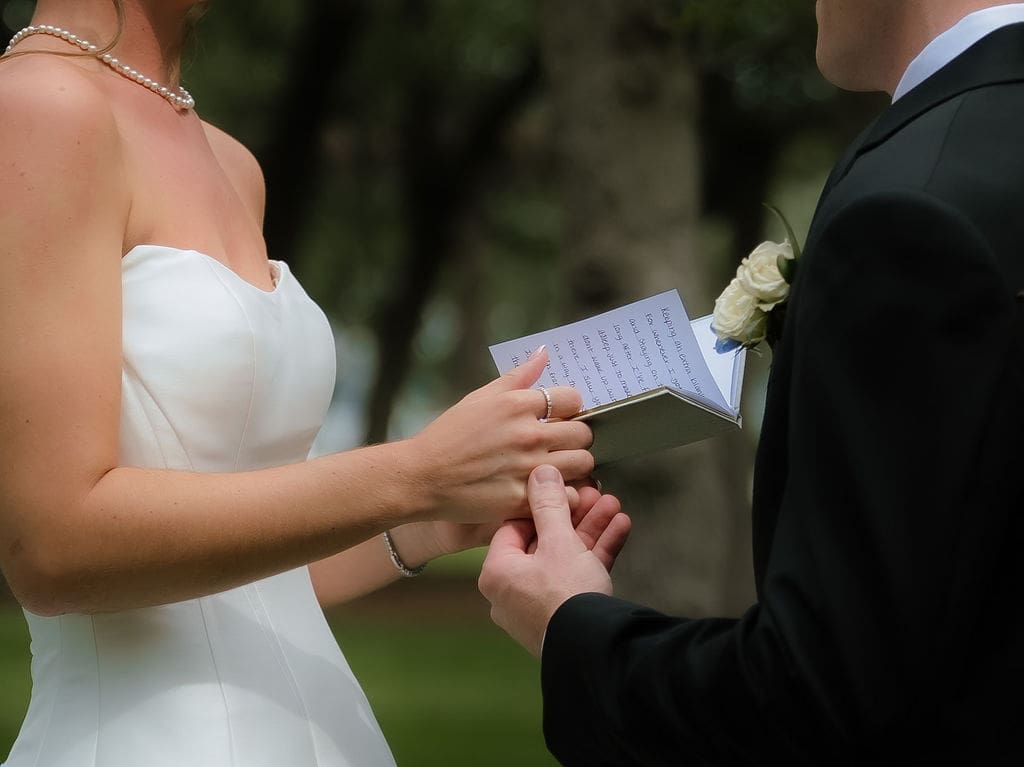 Bride and groom holding hands during a private vow reading at Canyonwood Ridge