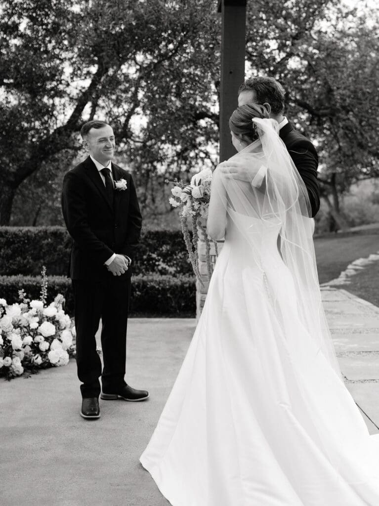 Groom smiling as his bride walks down the aisle at Canyonwood Ridge