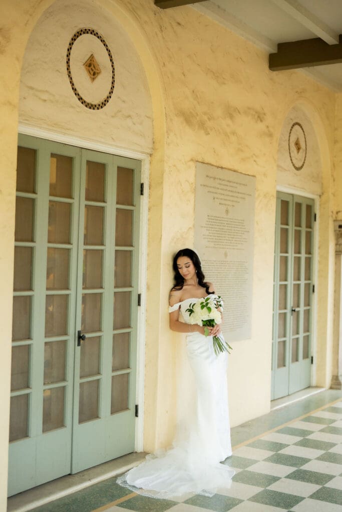 Bride in a white wedding gown standing in front of Landa Library in San Antonio Texas
