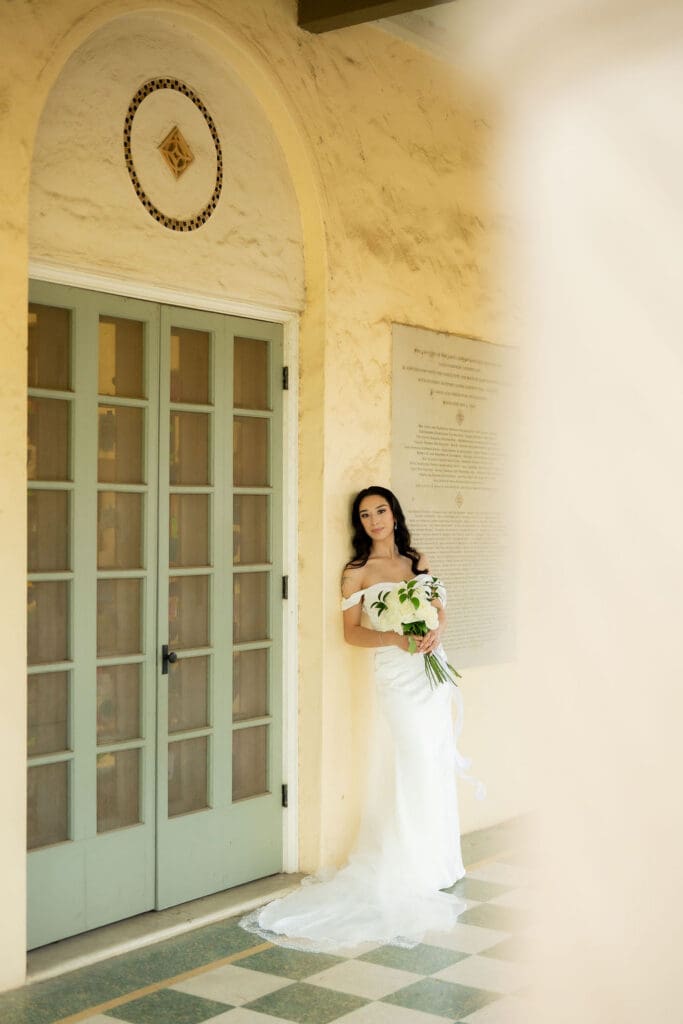 Bride in a white wedding gown standing in front of Landa Library in San Antonio Texas