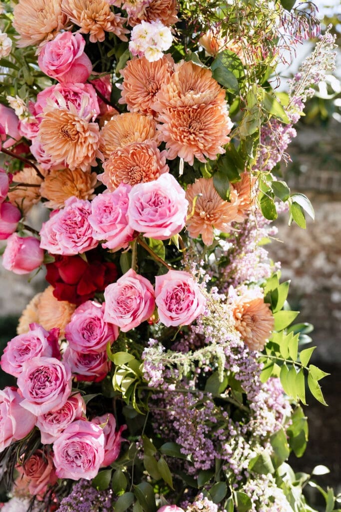 Lush floral ceremony arch with pink coral and peach blooms at The Gadsden House Charleston romance editorial