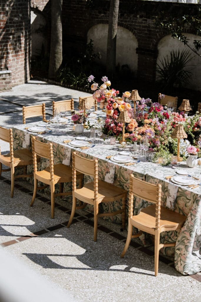 Outdoor wedding tablescape with botanical linen and colorful florals at The Gadsden House Charleston South Carolina