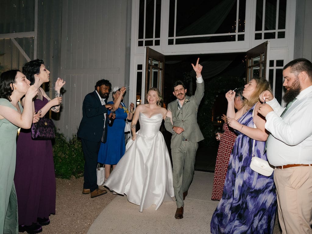 Bride and groom waving goodbye during their wedding send-off