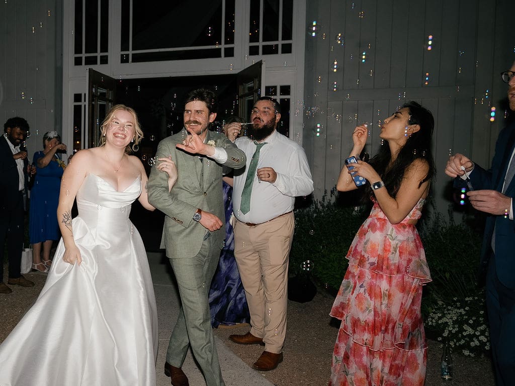 Bride and groom waving goodbye during their wedding send-off