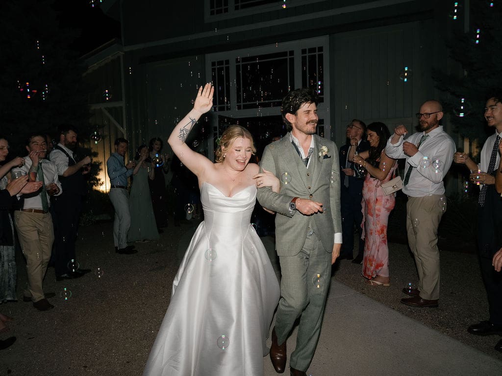 Bride and groom waving goodbye during their wedding send-off