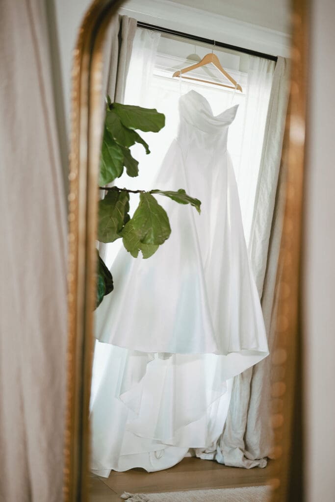 Dana's wedding dress hanging in the window on her wedding morning
