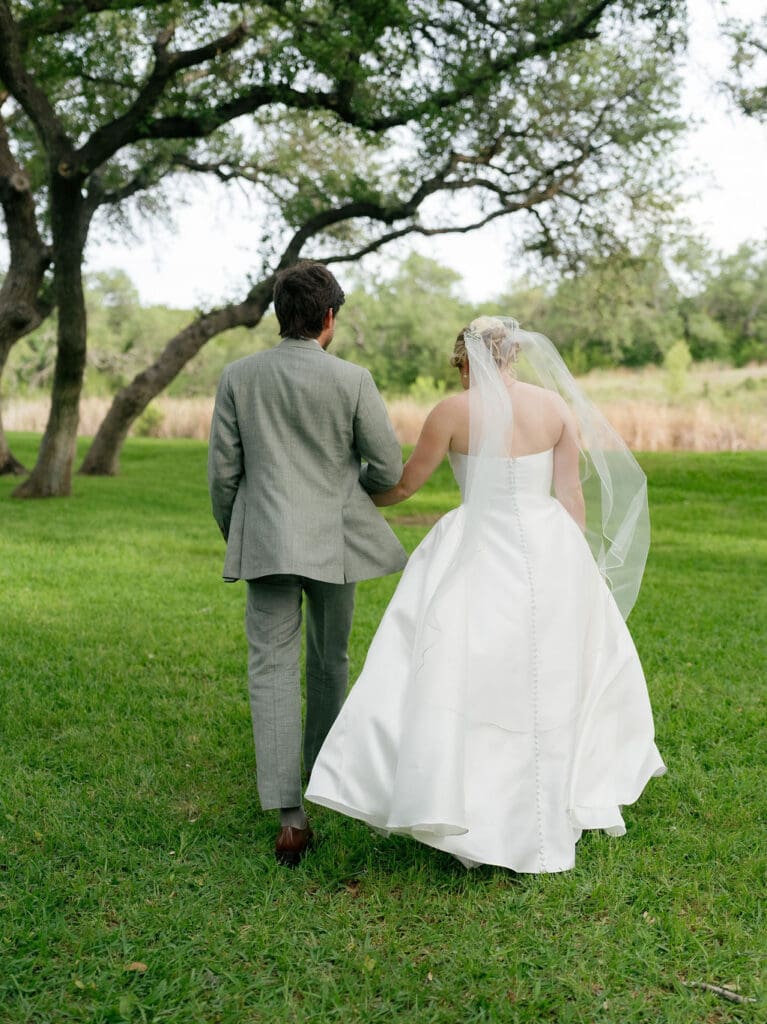 Dana and Jack walking hand in hand across the Addison Grove grounds