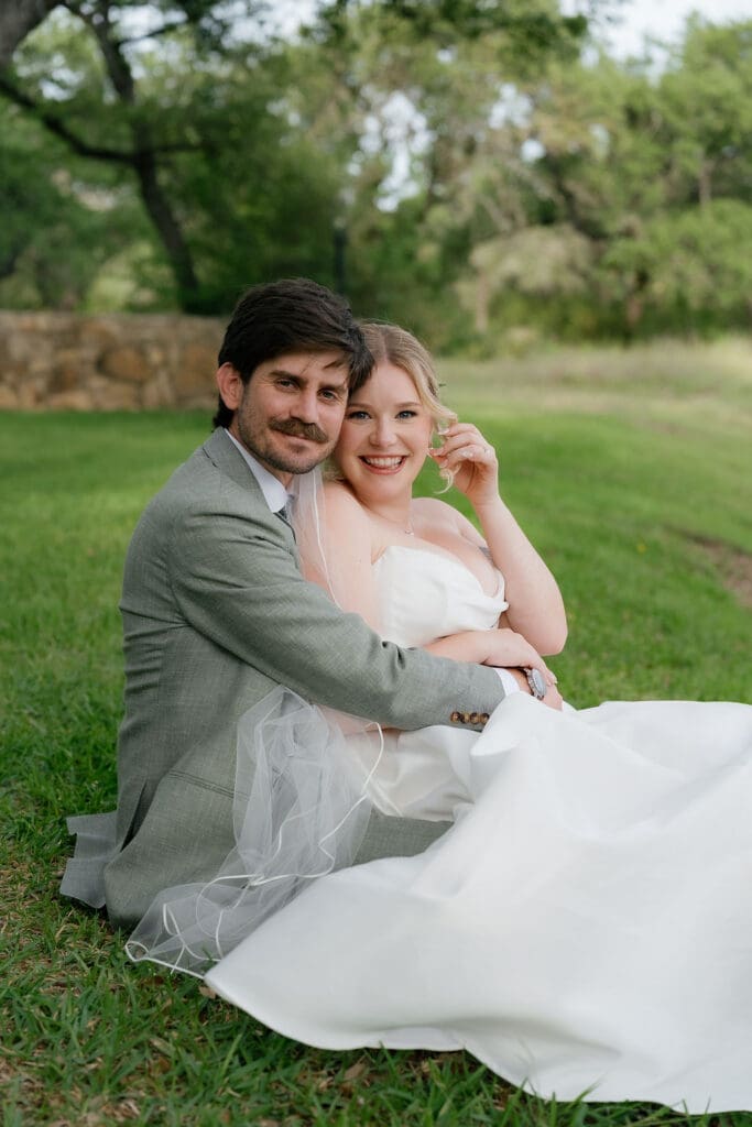 Bride and groom seating close together in soft summer light