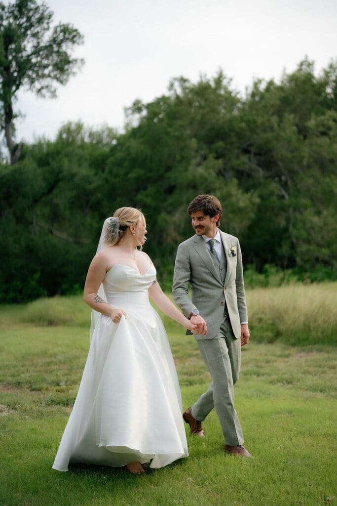 Dana and Jack walking hand in hand across the Addison Grove grounds