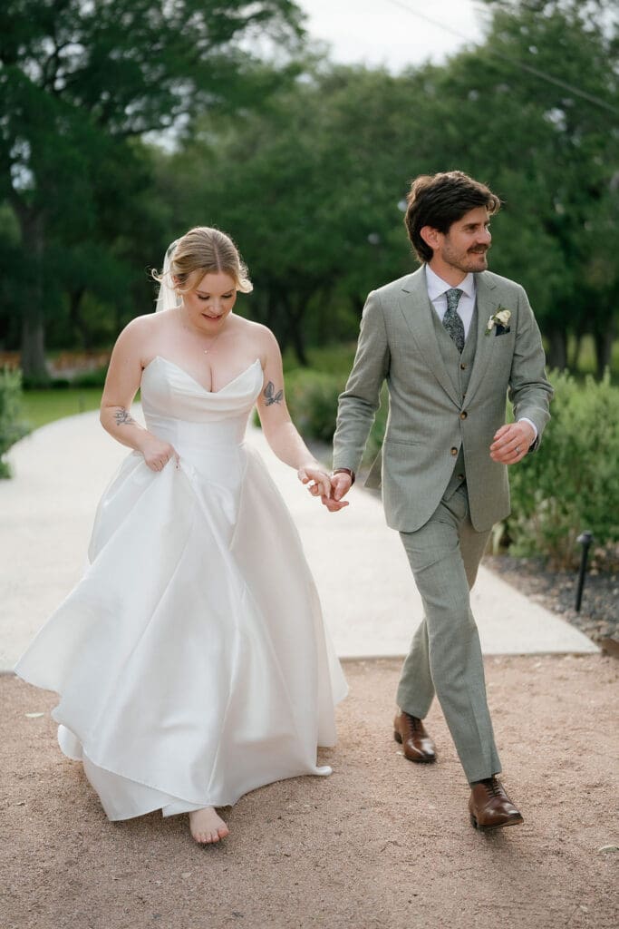 Dana and Jack walking hand in hand across the Addison Grove grounds