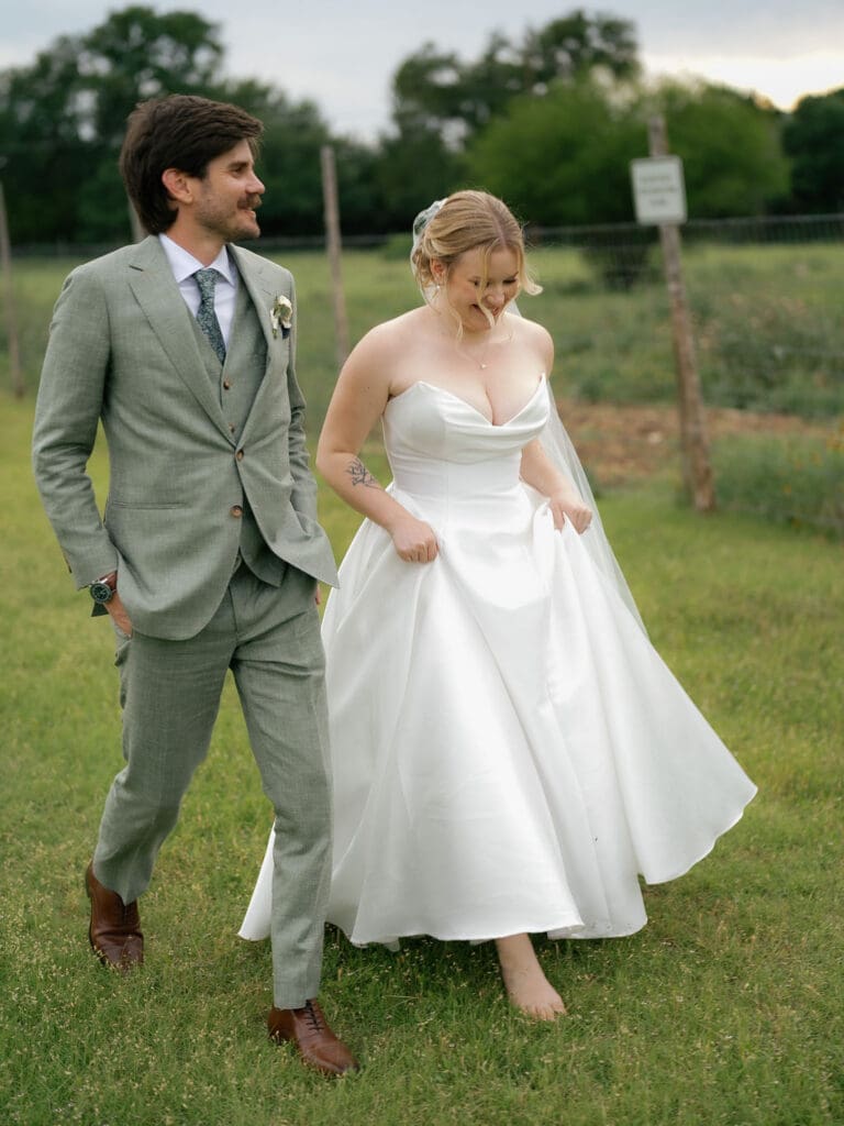 Barefoot bride walking the grounds on her Addison Grove wedding day