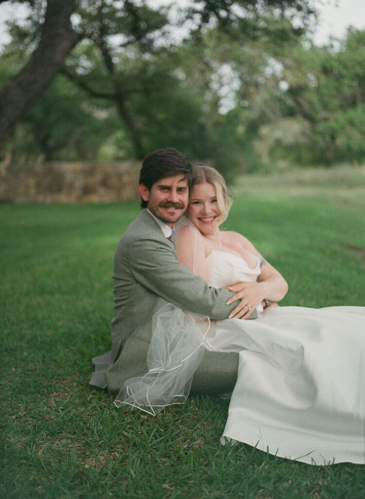 Bride and groom seating close together in soft summer light